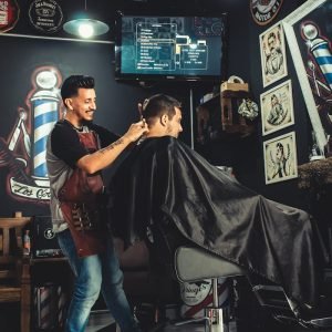 A barber skillfully cutting a mans hair in a trendy, well-decorated barbershop.